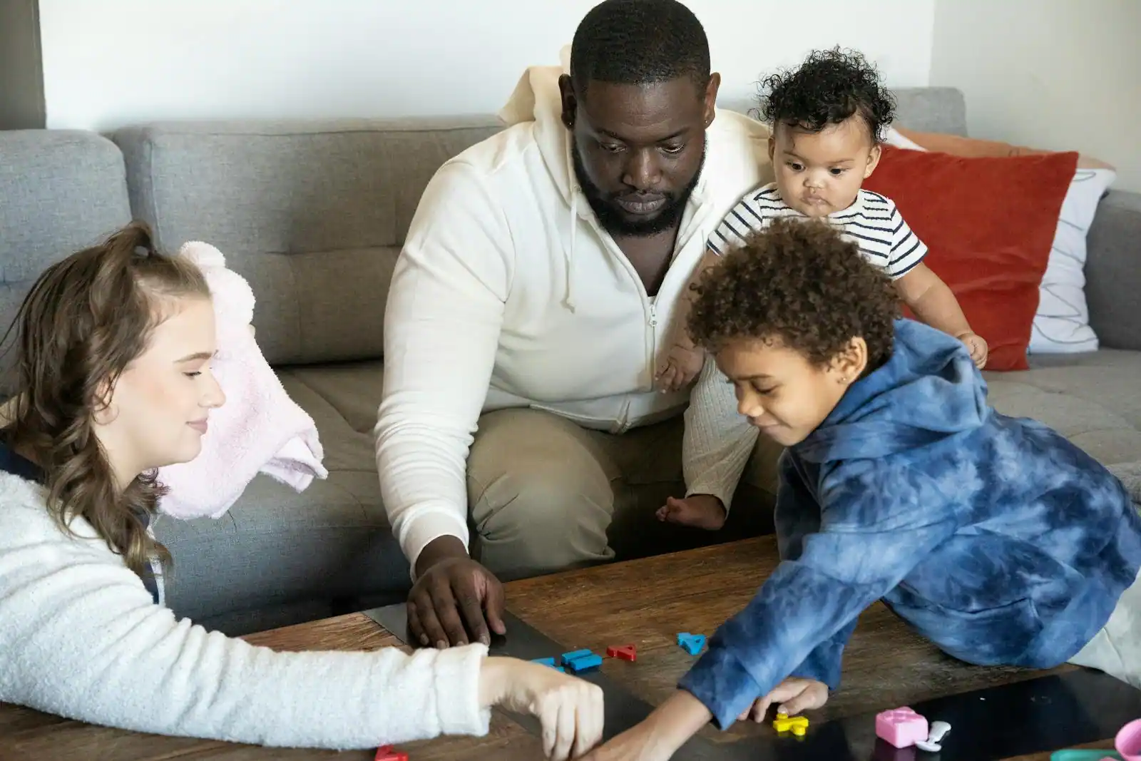 Parents et enfants réunis autour d'un jeu de société dans un salon lumineux
