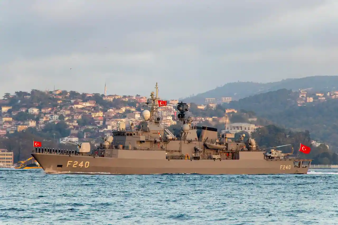 Navire de guerre gris de lutte contre les mines naviguant en mer sous un ciel couvert.