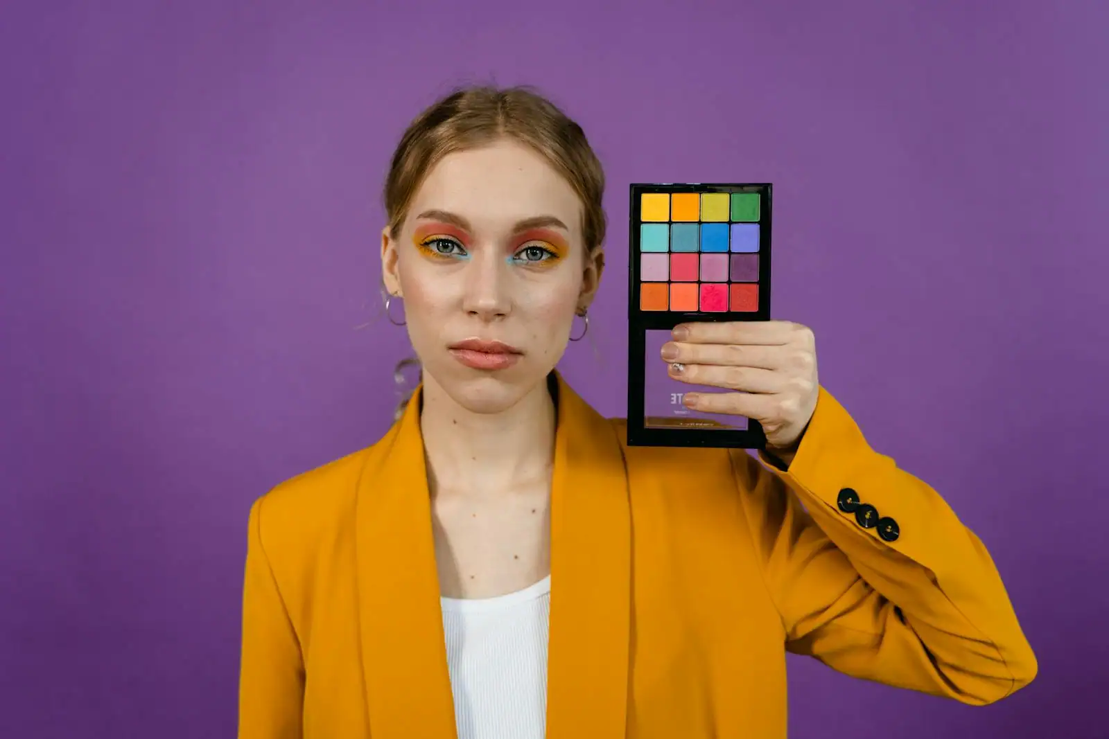Portrait d'une femme avec un maquillage coloré inspiré des années 80, fard à paupières vif et blush marqué