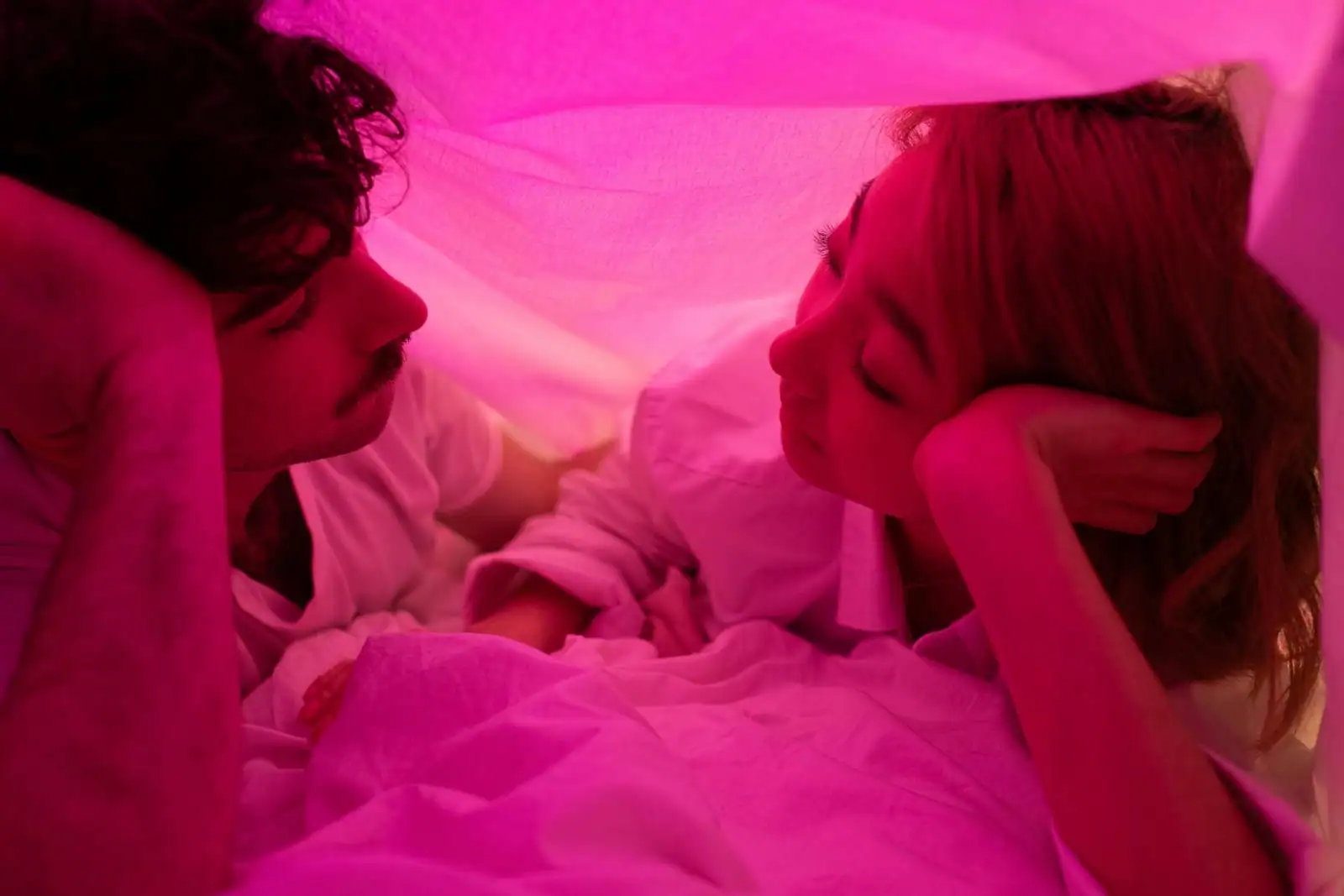 Couple complice échangeant un regard intense dans une lumière tamisée