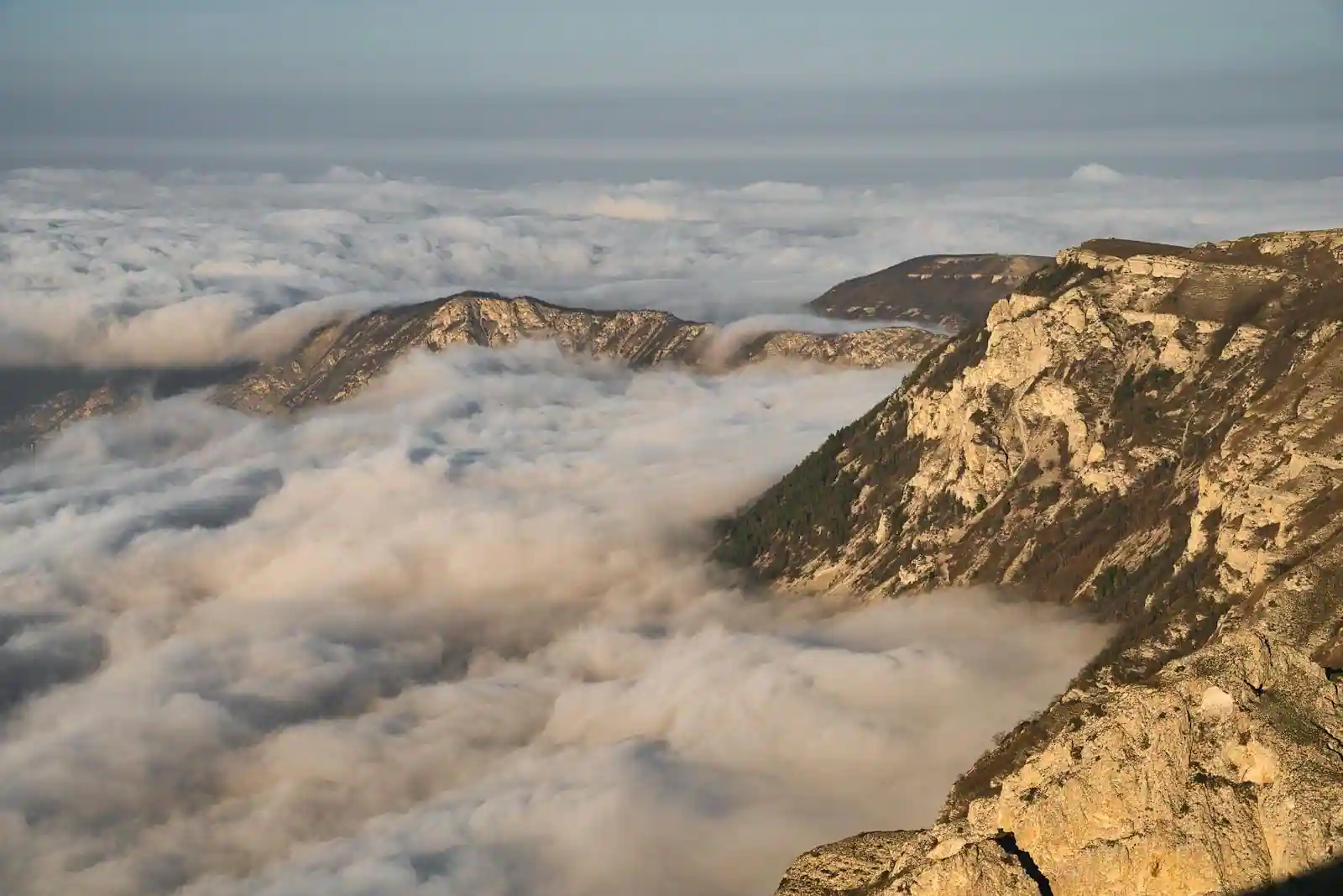 Chaîne de montagnes volcaniques émergeant au-dessus des nuages, paysage de zone de subduction