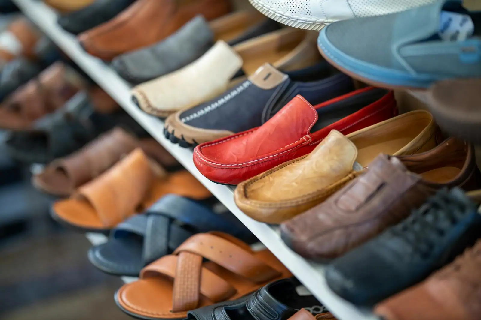 Mocassins en cuir de différentes couleurs présentés en rangée sur les étagères d'une boutique