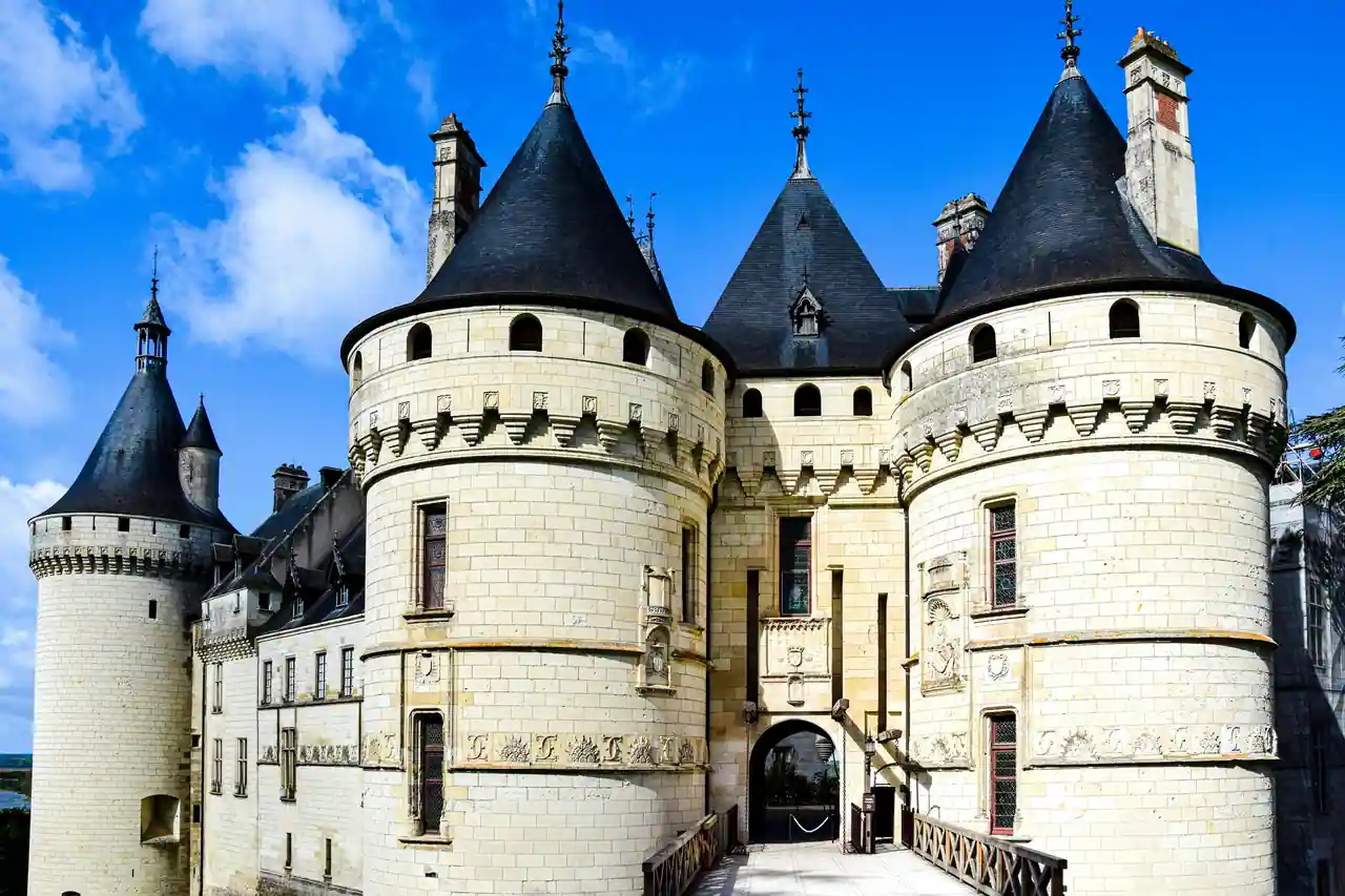 Château français de style Renaissance, aux tours rondes coiffées de toits d'ardoise, sous un ciel bleu