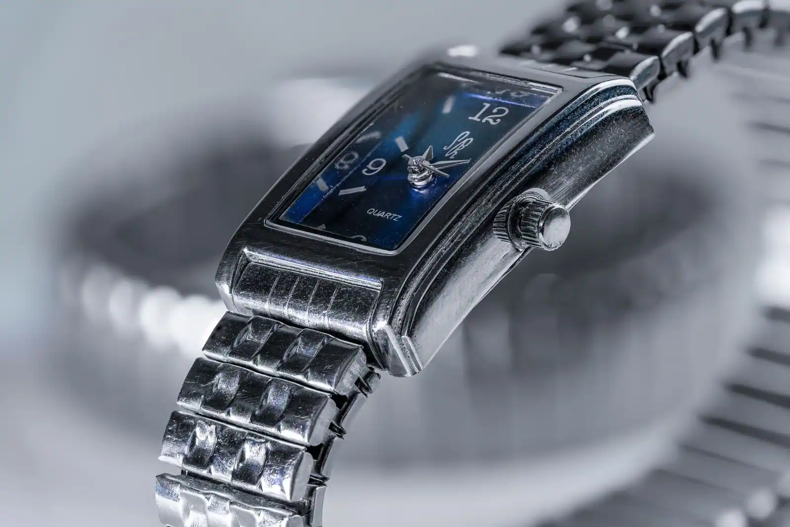 Montre-bracelet à quartz au boîtier rectangulaire argenté et cadran bleu, bracelet en acier, en gros plan