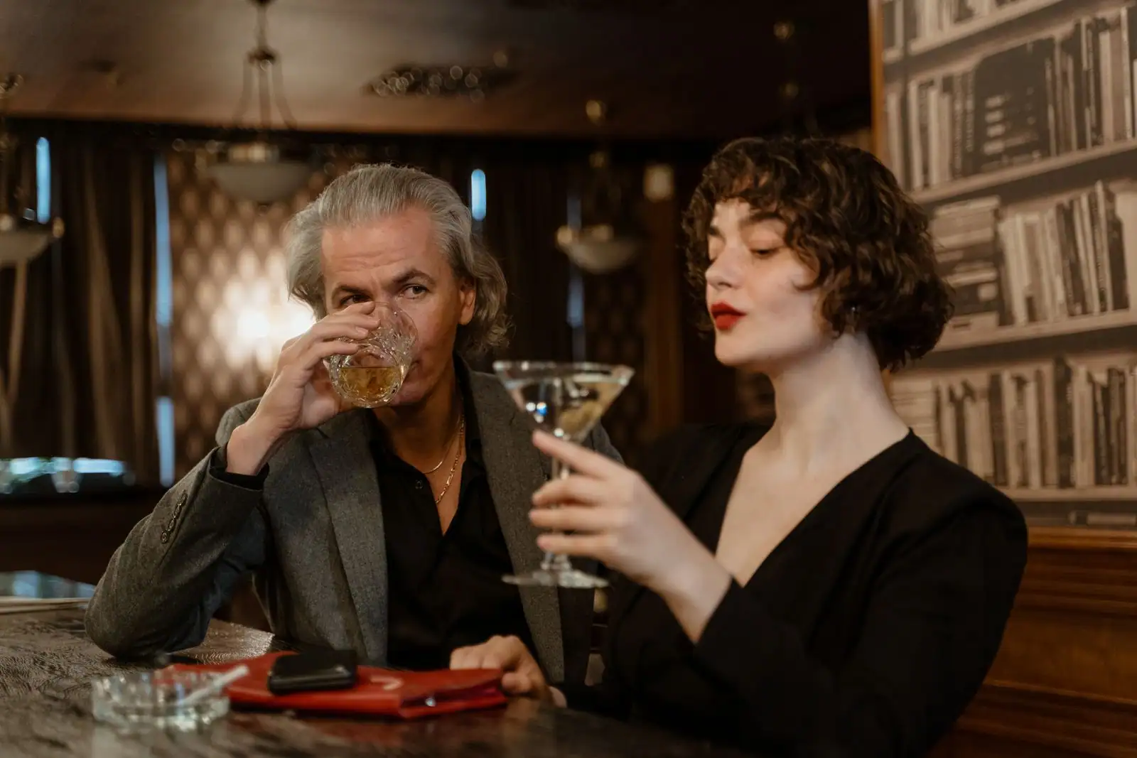 Couple élégant partageant un verre dans un bar feutré et raffiné