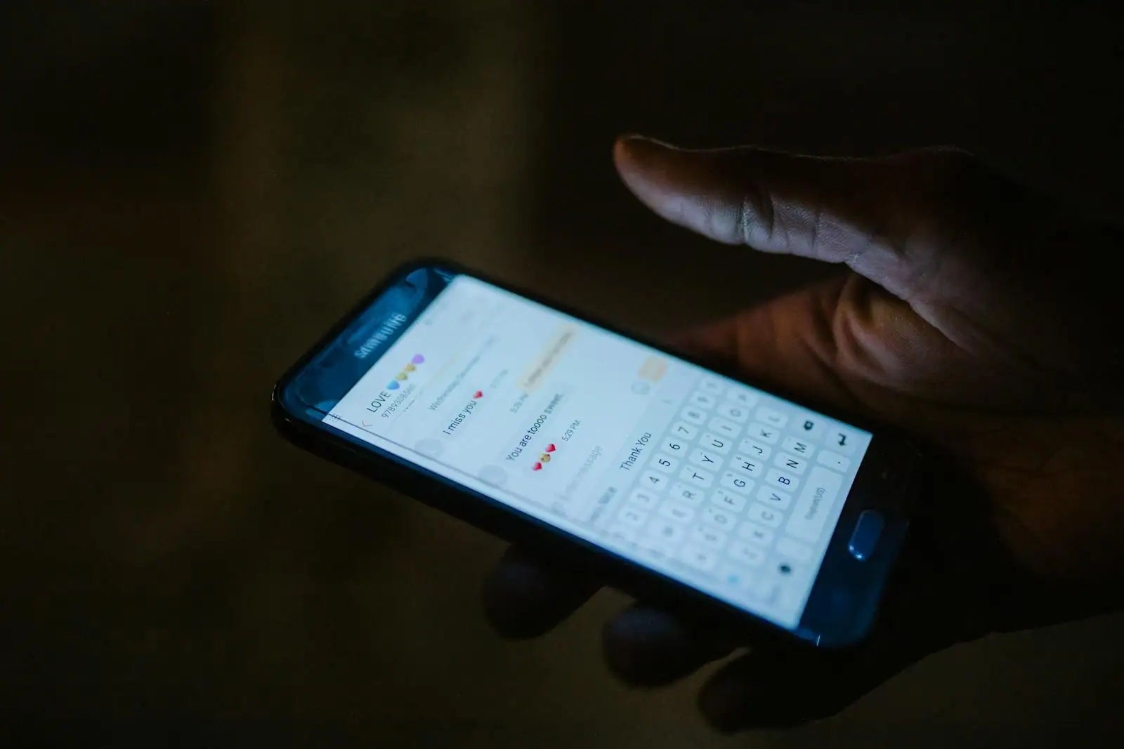 Personne tenant un smartphone affichant une application de messagerie, image illustrative d'une rencontre en ligne.