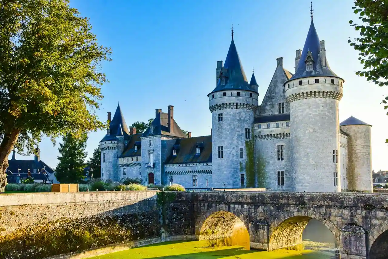 Château médiéval de Sully-sur-Loire avec ses tours coniques et son pont de pierre au-dessus des douves