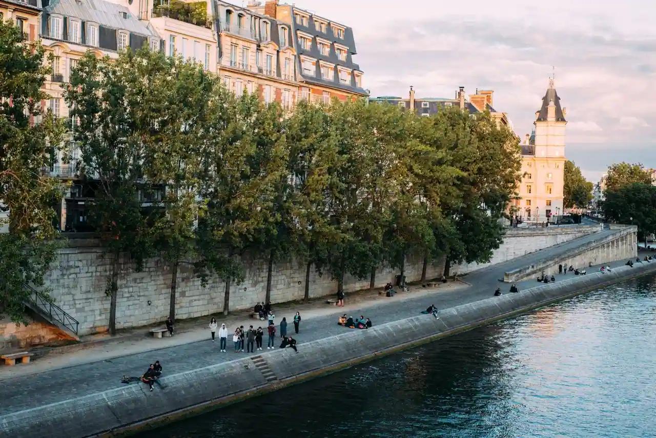 Quais de Seine animés à Paris par un après-midi d'été, promeneurs le long du fleuve