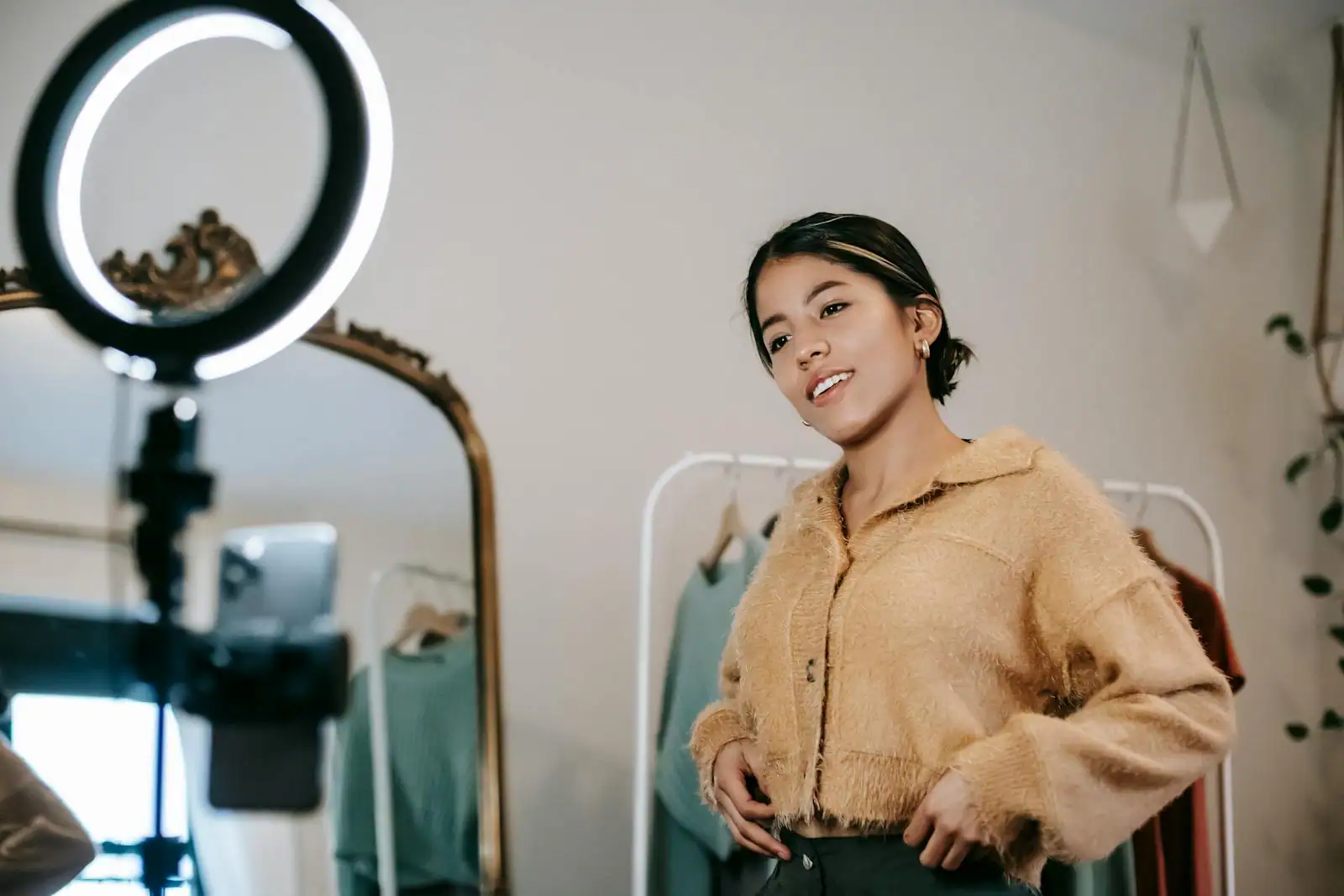 Jeune femme filmant une vidéo verticale avec un smartphone sur trépied et anneau lumineux