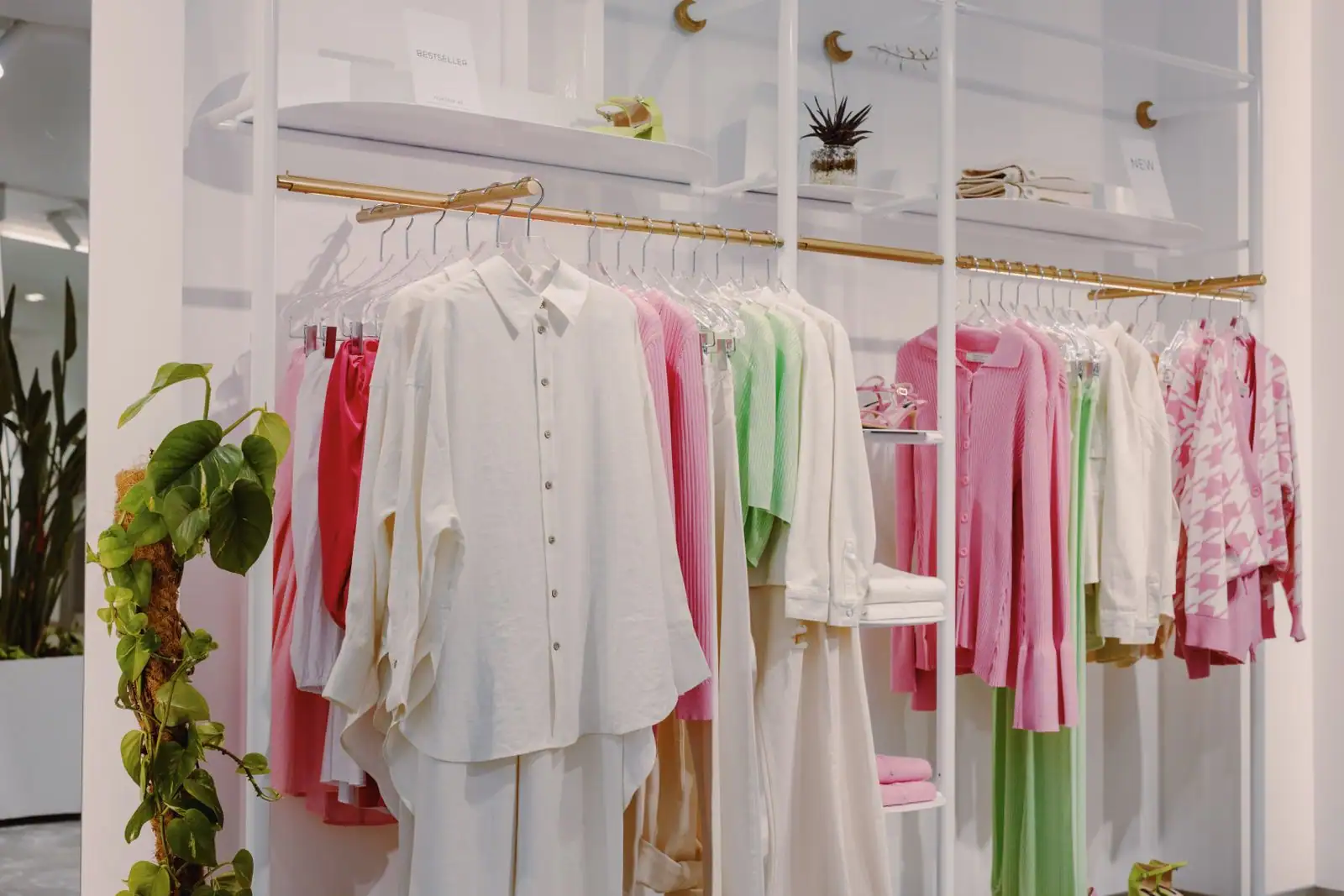 Portants de vêtements colorés alignés dans une boutique de prêt-à-porter moderne