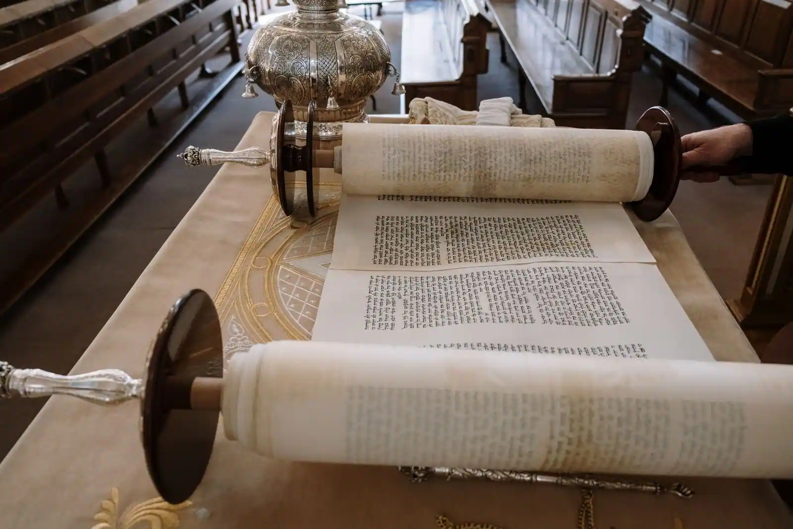 Rouleau de la Torah ouvert sur son parchemin, colonnes de texte hébreu manuscrit visibles