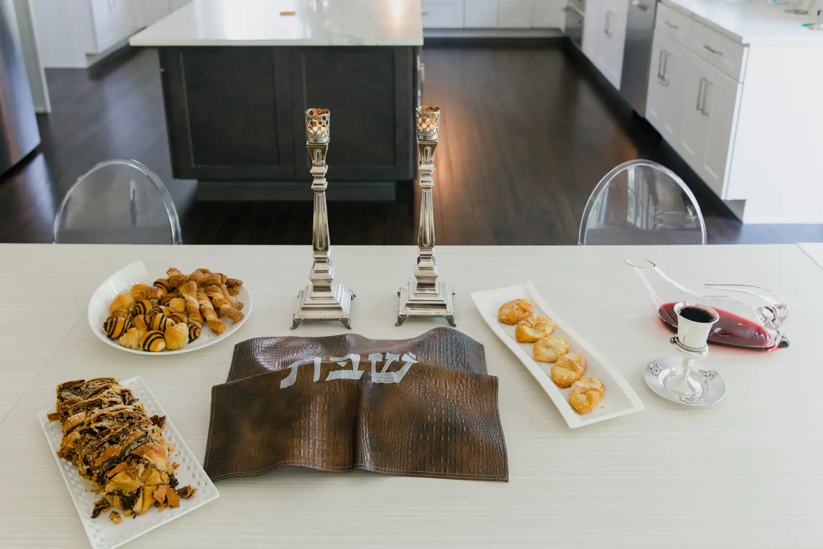 Table de chabbat dressée : deux chandeliers, couvre-pain brodé, vin du kiddouch et pâtisseries