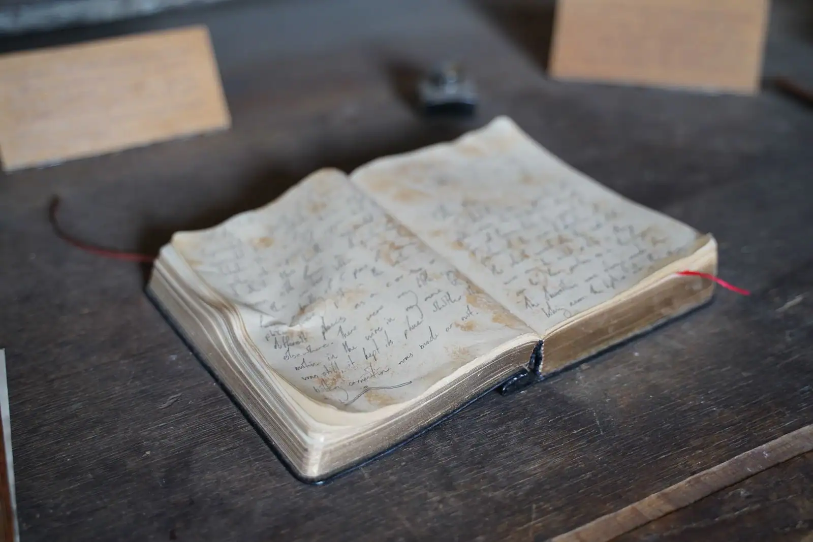 Un livre ancien ouvert posé sur une table en bois, dans une lumière douce du matin
