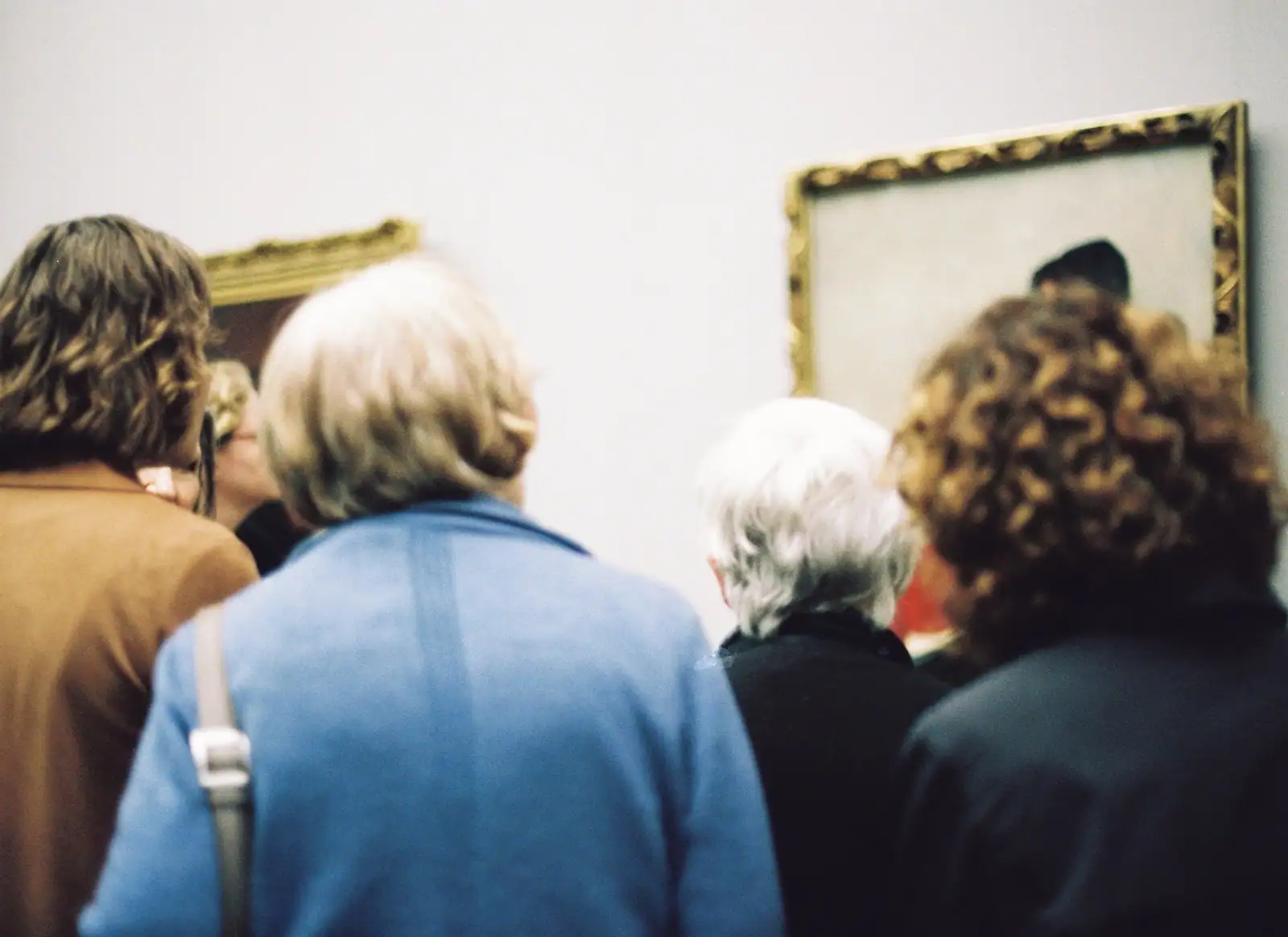 Grande salle de musée avec visiteurs observant des œuvres d'art exposées