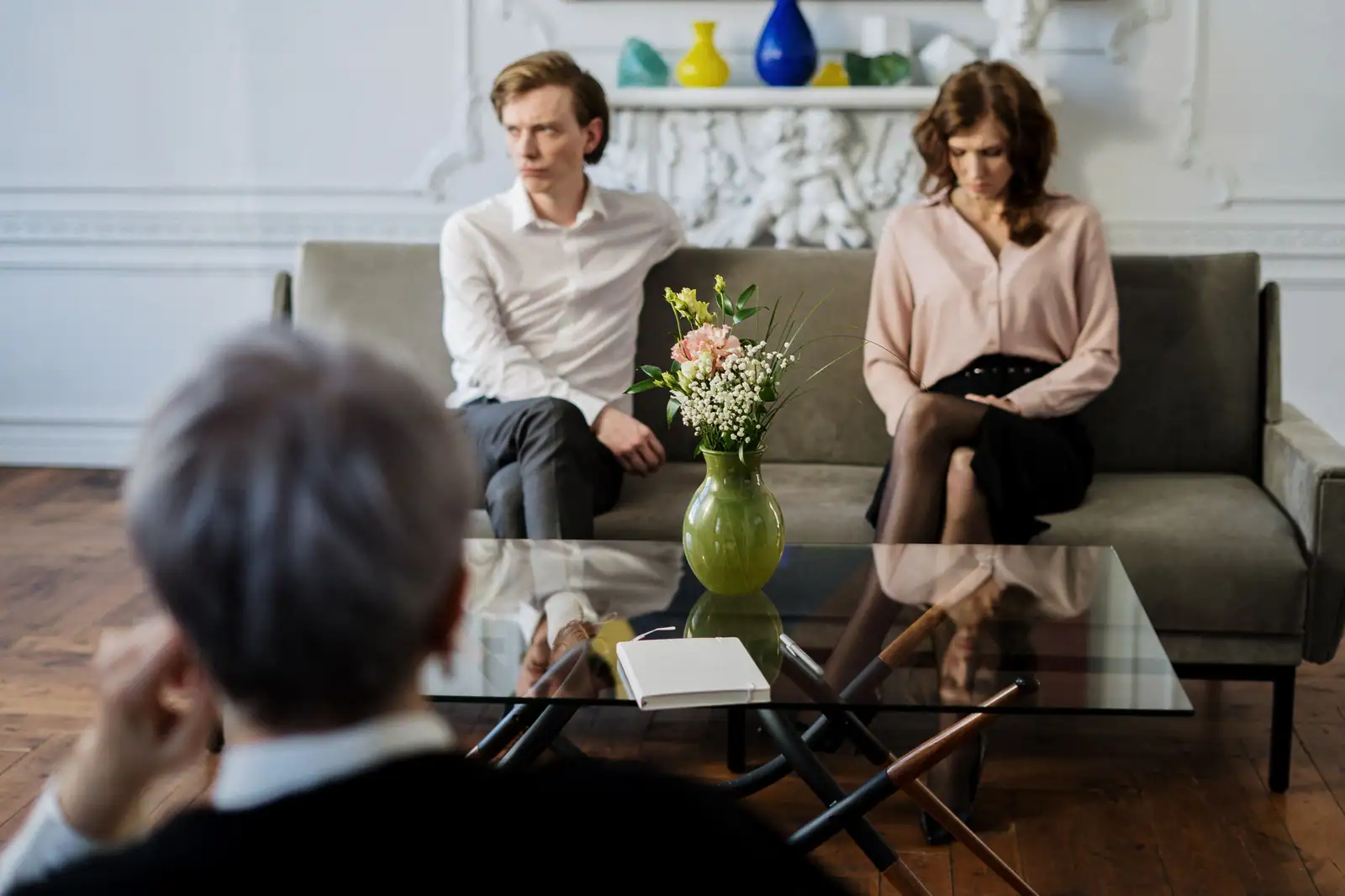 Un couple assis sur un canapé, en consultation avec un professionnel de l'accompagnement