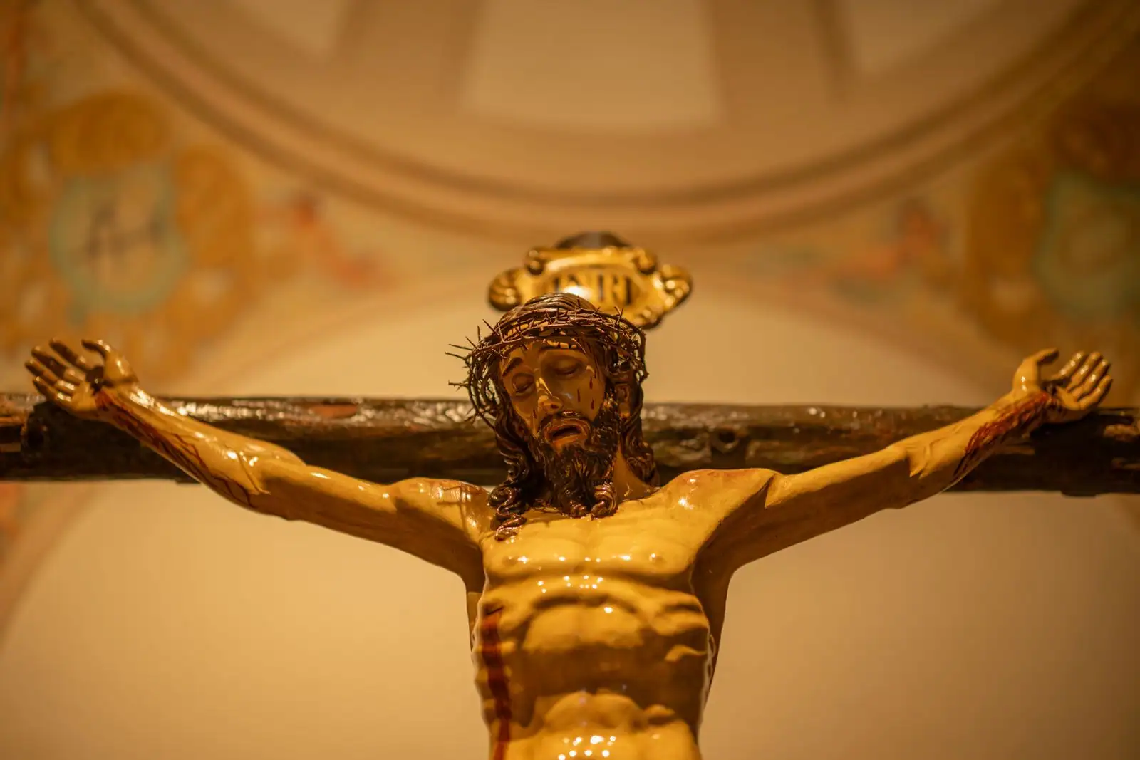 Crucifix en bois à l'intérieur d'une église, symbole du récit chrétien de la Passion